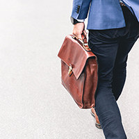 "man from behind walking with a briefcase"